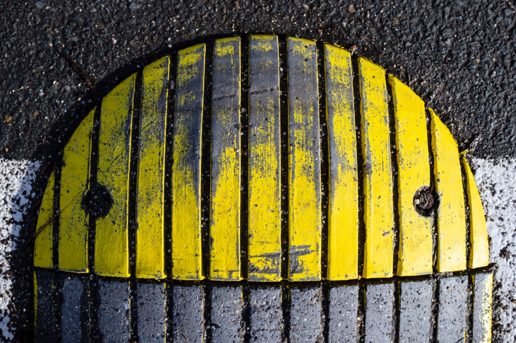 Close-up of a yellow and black speed bump showcasing creative ways to slow down traffic