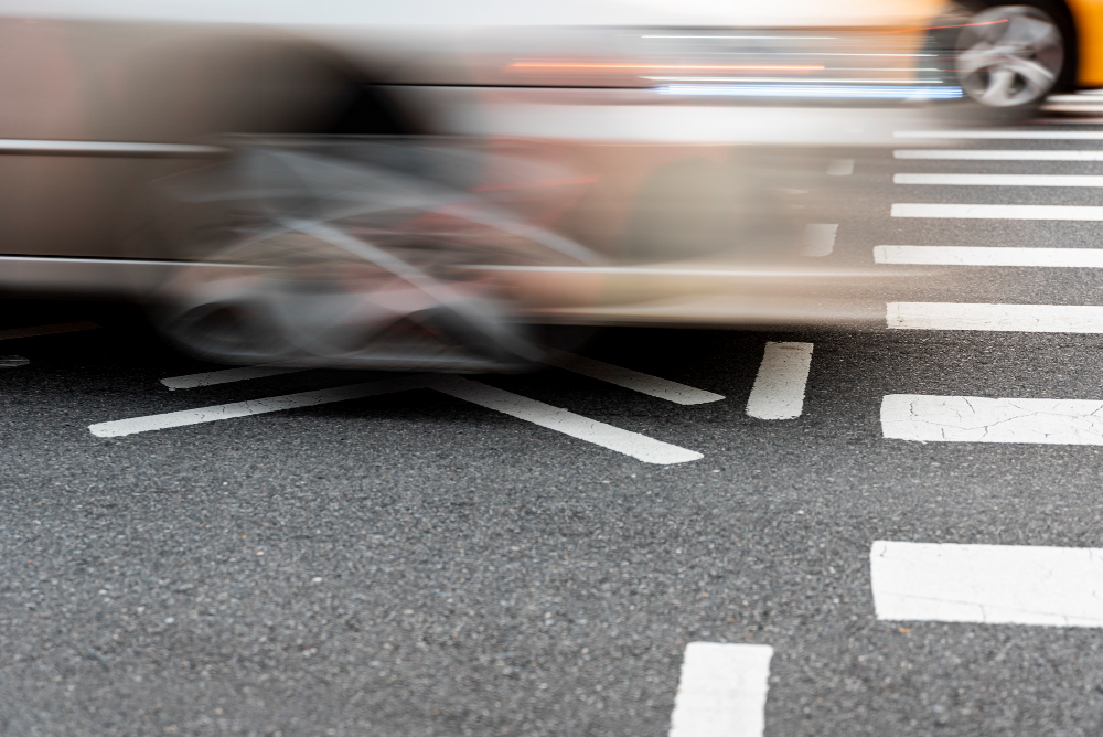 A blurred car crossing marked lines, illustrating traffic calming in action.